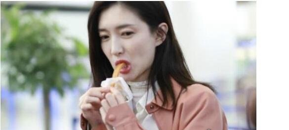 江疏影机场吃辣条 和粉丝分享自己的零食还贴心的为其擦汗